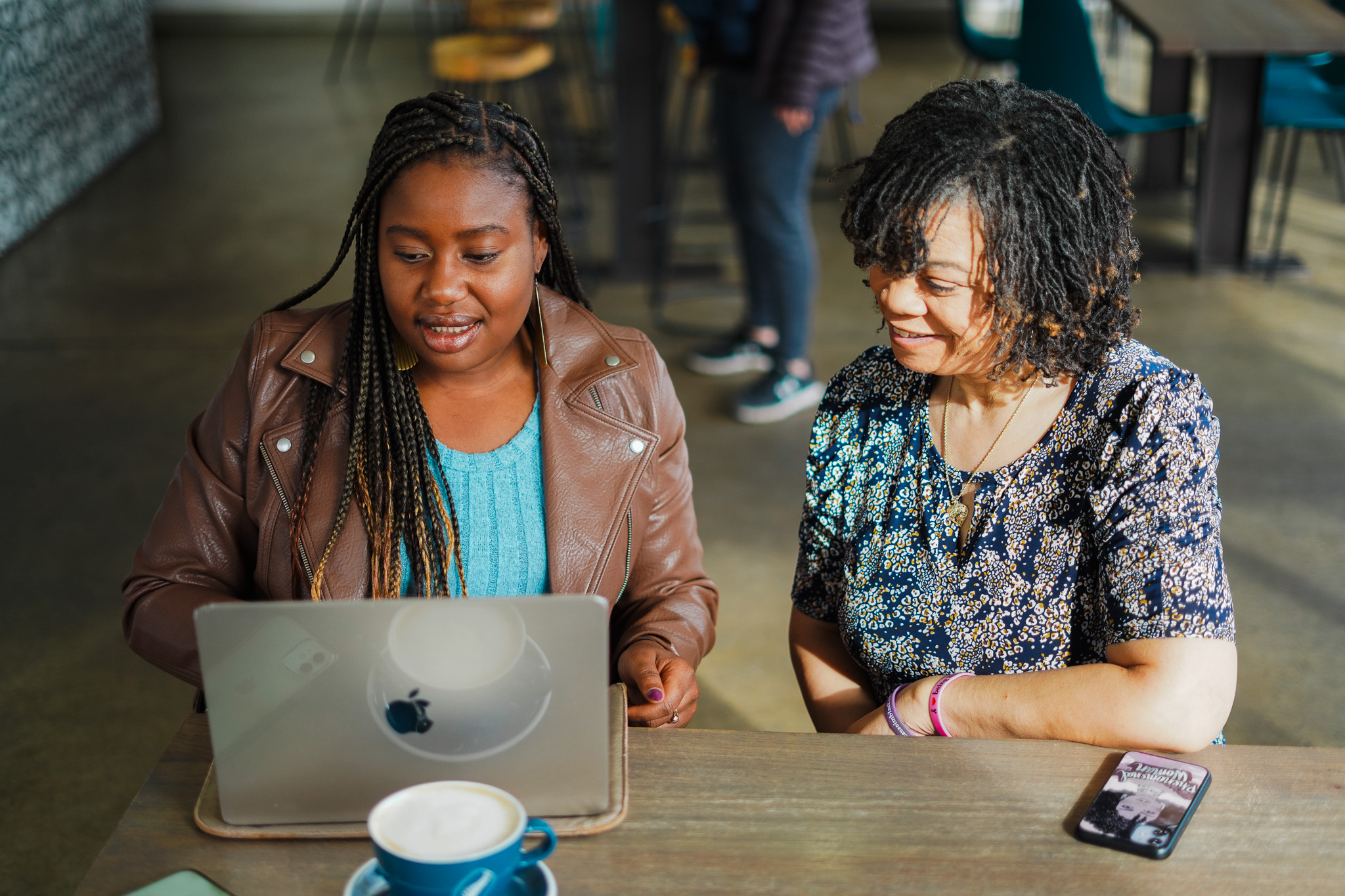Smiling man and woman working on laptop at cafe