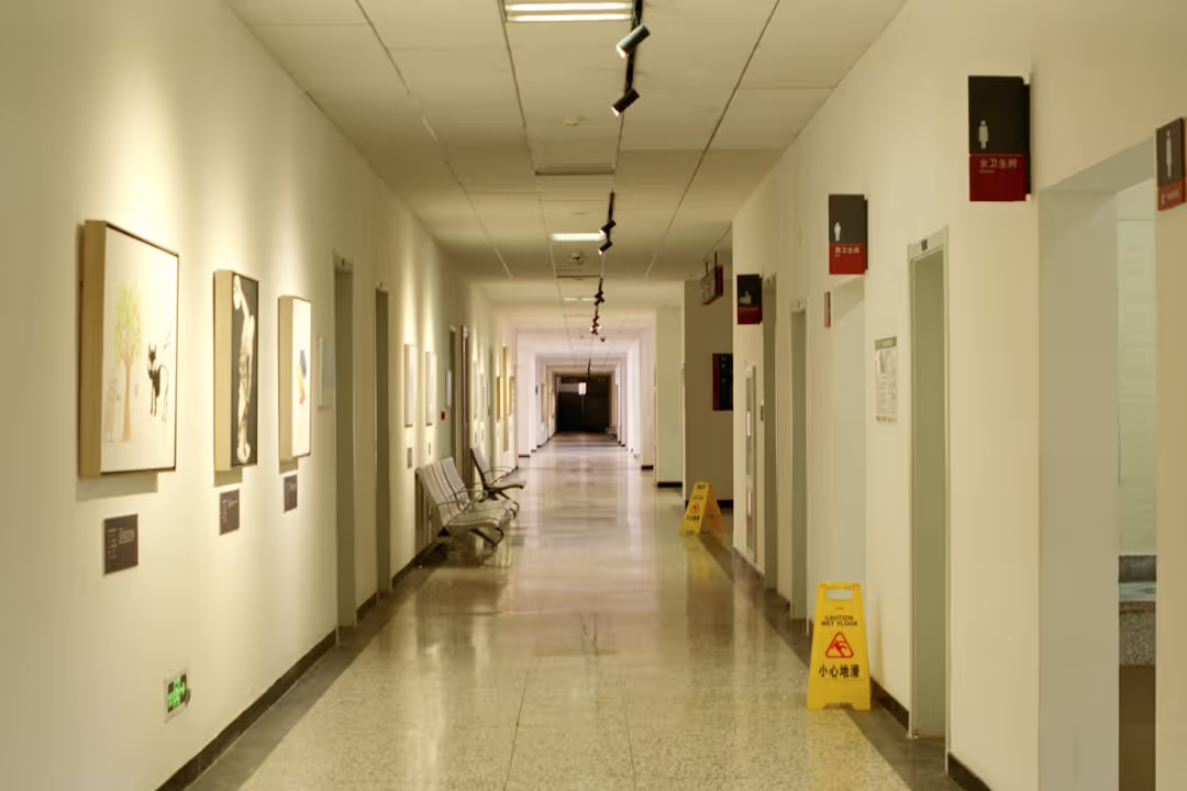 A bright and clean hospital corridor with modern design elements and clear directional signage.