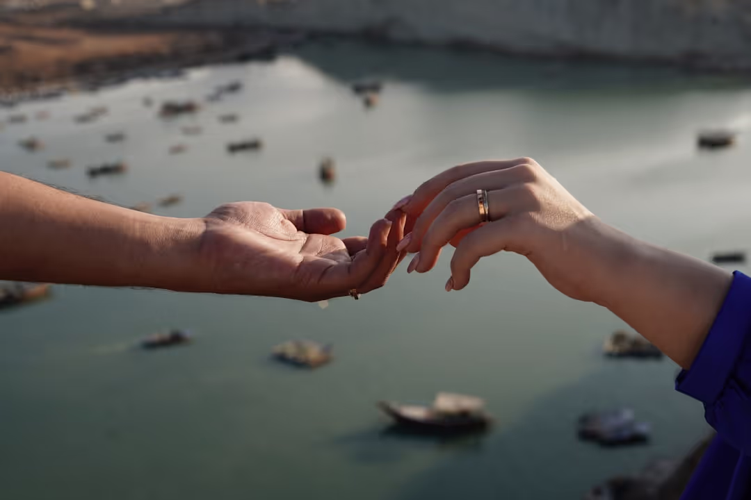 Close-up of hands gently holding several smooth river stones in soft natural light, symbolizing peace and connection to nature.