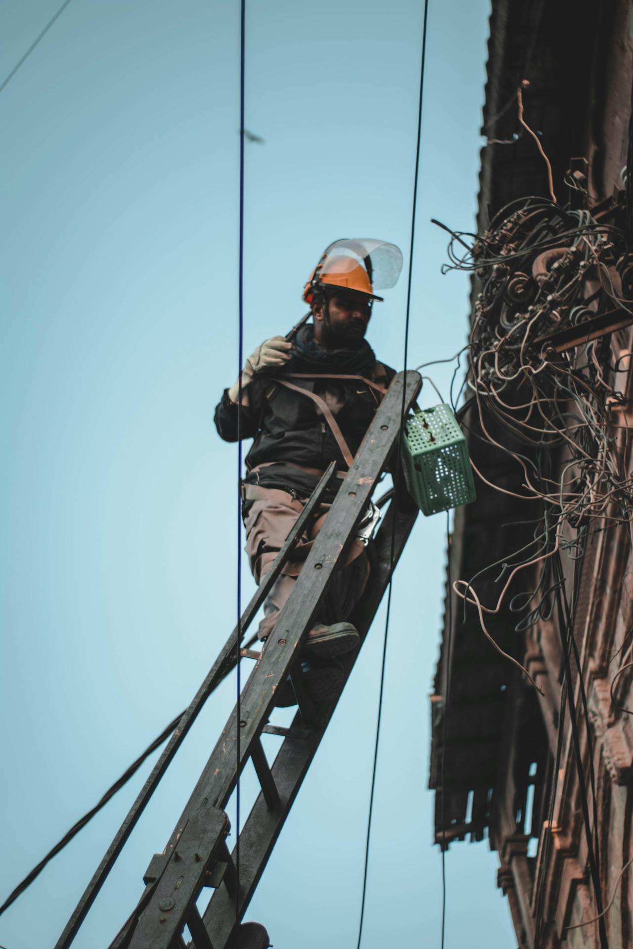 Electrician repairing electrical wires on a utility post, part of insulated wire recycling Sacramento workflow.