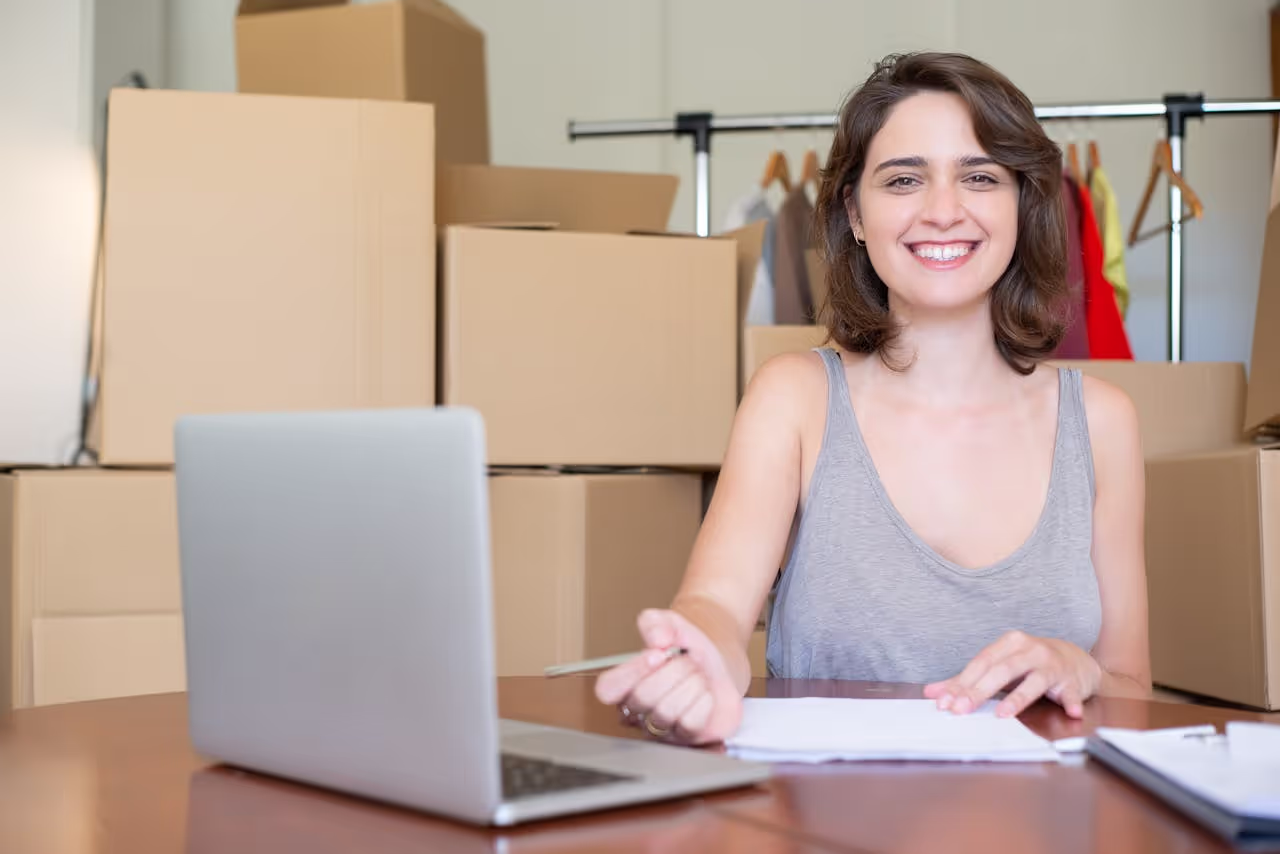 Amazon PPC Exit Planning – Start Optimizing Early for Maximum Payout Smiling woman online seller computing her sales, symbolizing the success that comes from starting Amazon PPC Exit Planning early to maximize FBA business payout.