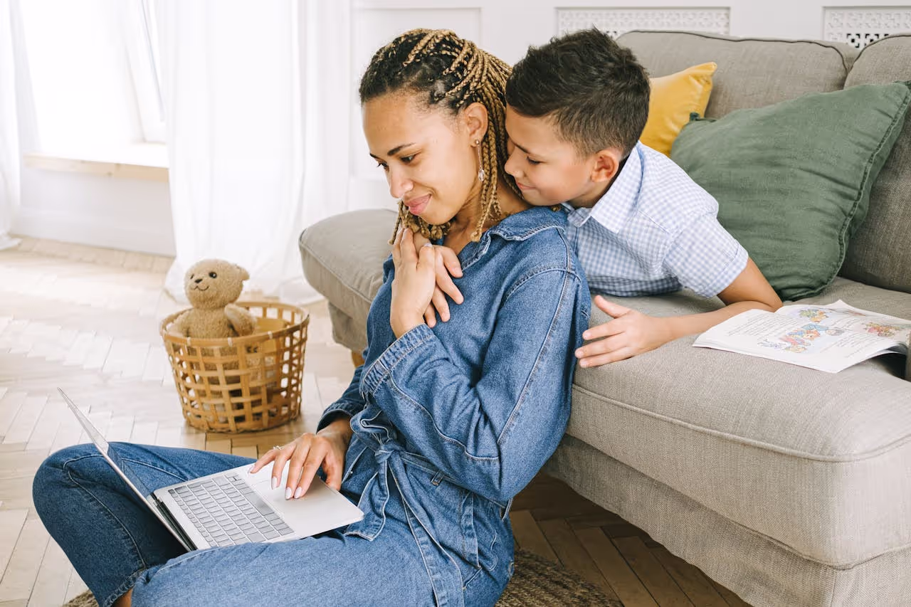 Student parent studying with child nearby, representing efforts to support student parents college success through family-friendly campus environments.