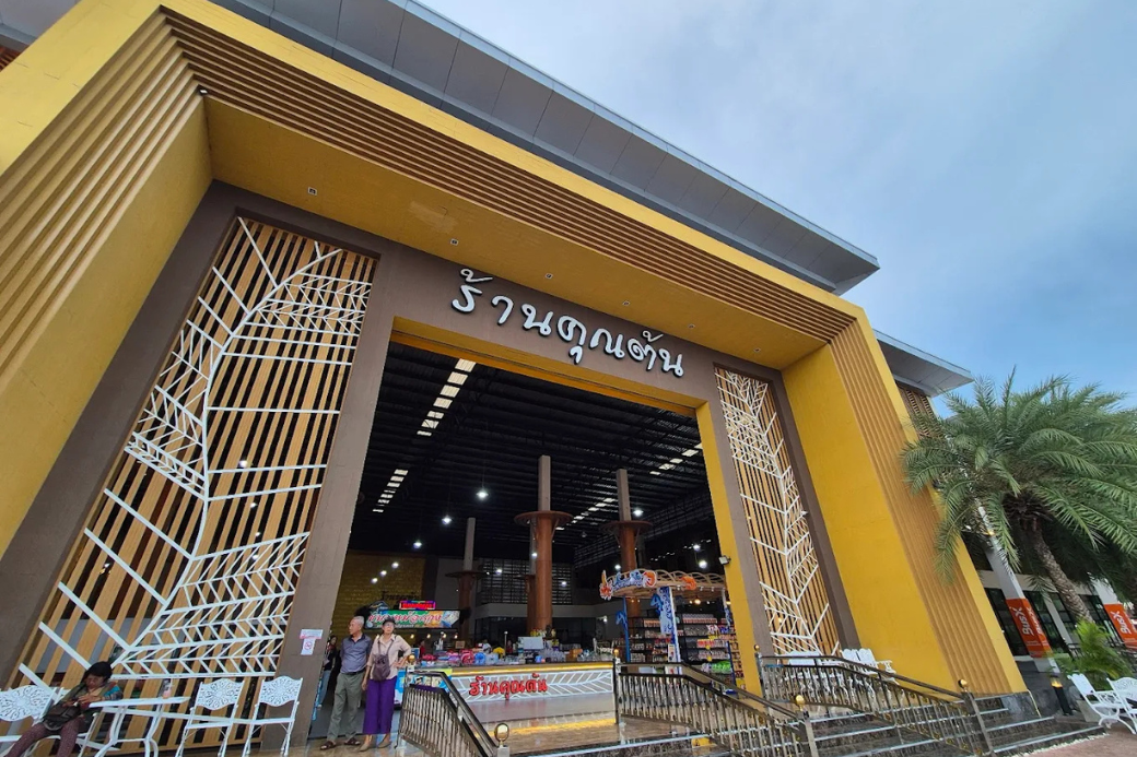 ภาพมุมกว้างของศูนย์อาหารคุณต้น ทับสะแก ที่จอดรถกว้างขวาง และอาคารศูนย์อาหาร