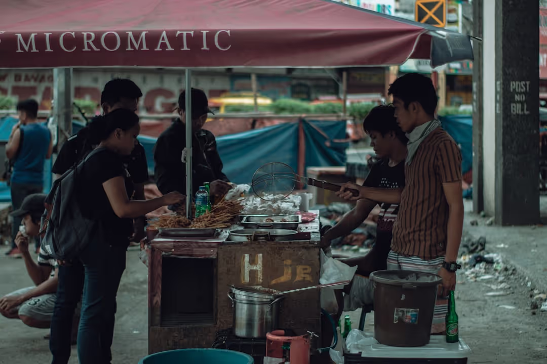 A bustling Filipino street food market with colorful lanterns and people enjoying local delicacies