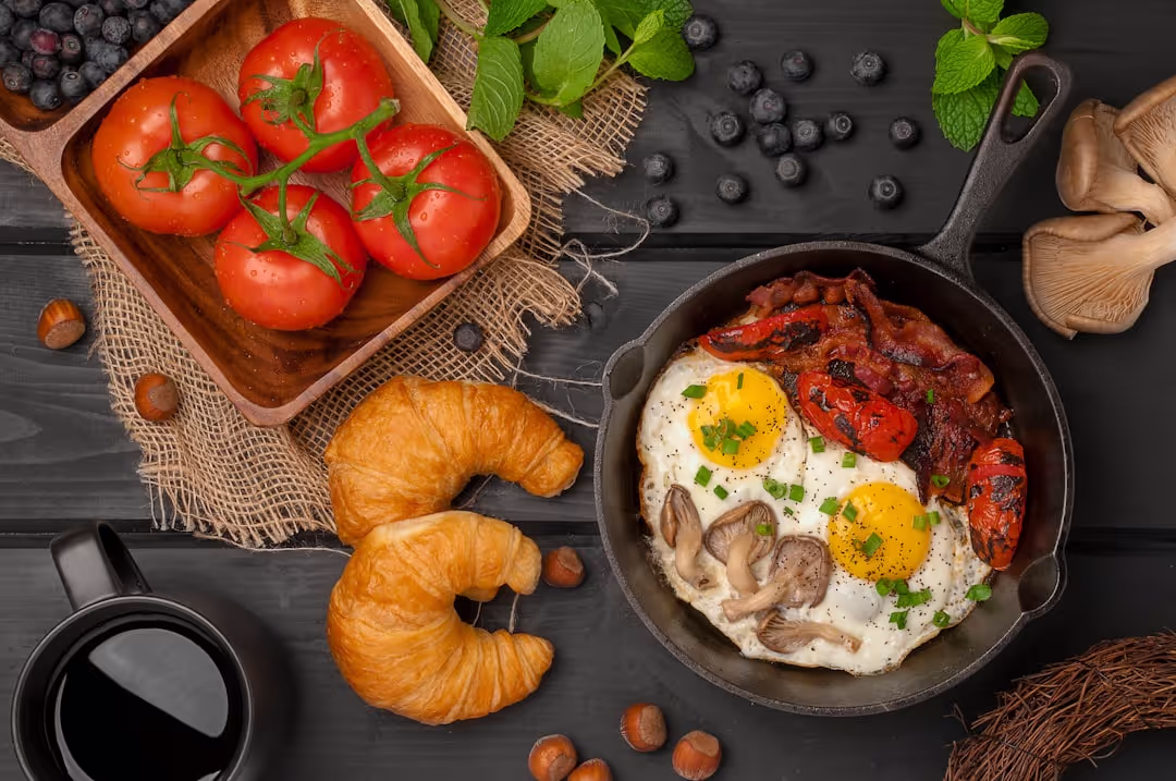 A vibrant breakfast bowl featuring scrambled eggs, crispy bacon, avocado, and fresh greens.
