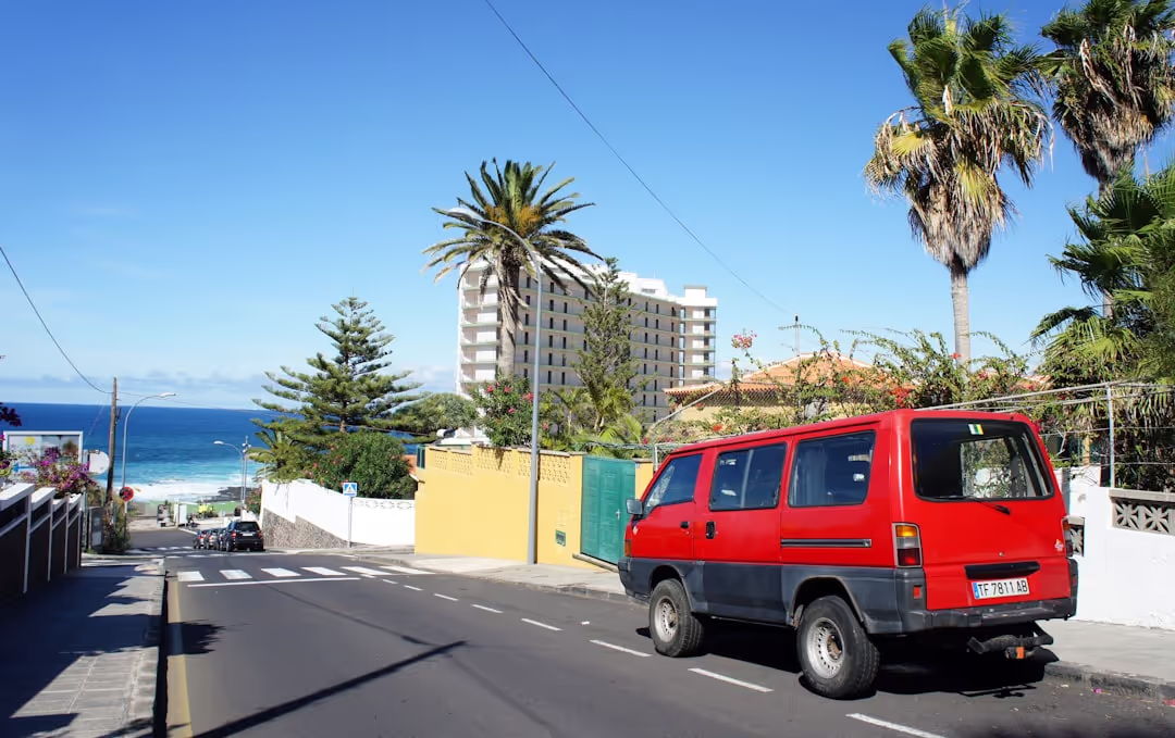 Red T4 camper van by a lighthouse in Portugal