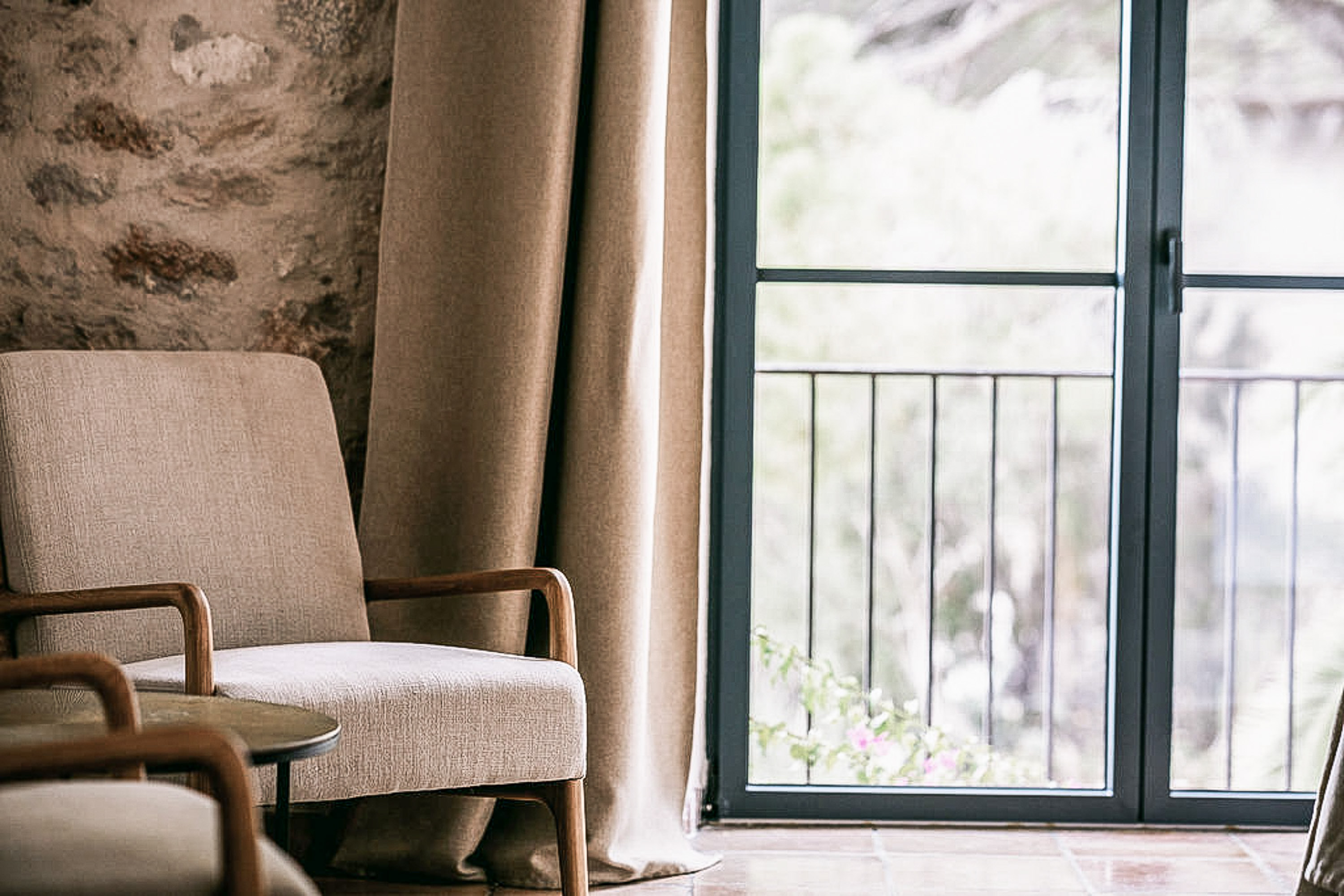 A calm, minimalist hotel room with abundant natural light, embodying slow design luxury.