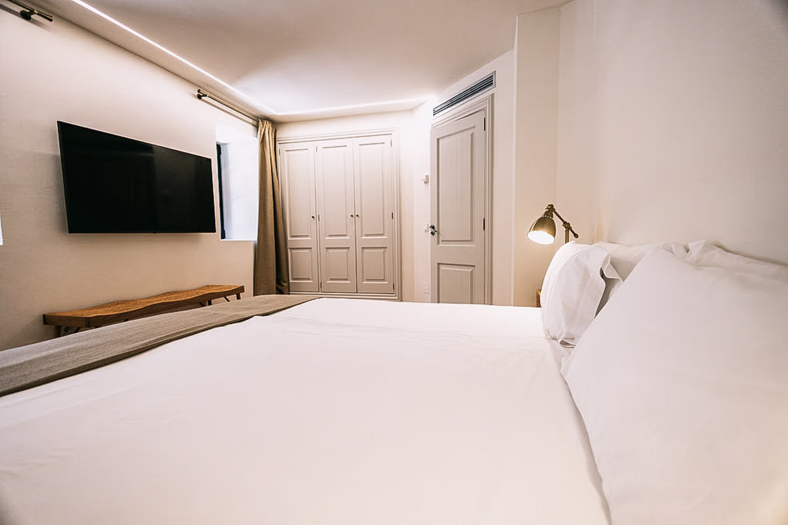 Luxurious king-size bed with pristine white linens and decorative pillows