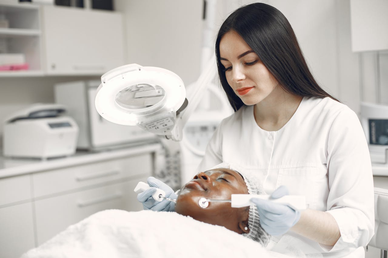 A dermatologist applies skincare treatment to a client in a clinic setting