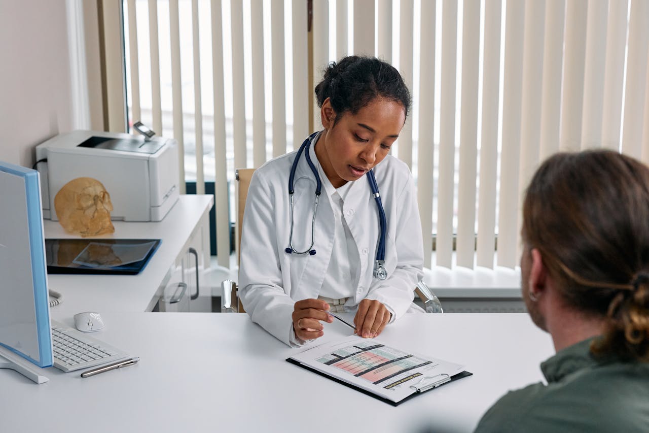 A doctor consulting with a patient in an office discussing a medical chart