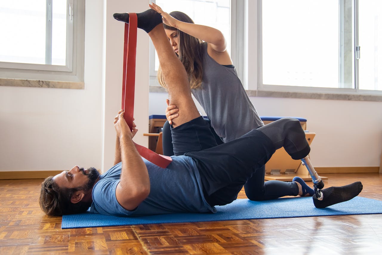 Man in rehabilitation exercises with a trainer focusing on prosthetic leg recovery